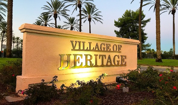 Village Of Heritage metal signage attached to a cement wall with outdoor light | homes for sale in heritage village fontana ca | Alvin Tapia