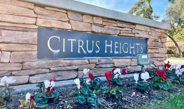 Brick wall with Citrus Heights signage and red and white flowering plants | Homes For Sale in Citrus Heights | Alvin Tapia