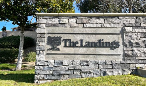Gray brick wall with The Landings Signage and green surroundings | landings real estate | Alvin Tapia